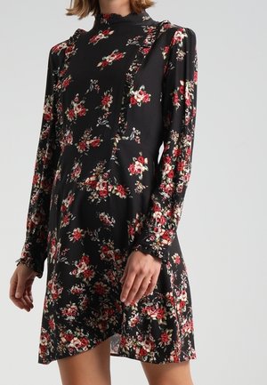 Schwarzes Kleid mit langen Ärmeln, rotem und weißem Blumenmuster, hohem Kragen und Rüschendetails entlang der Vorderseite und Manschetten.