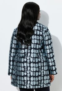 Cappotto lungo con motivo, caratterizzato da una base blu navy scuro con disegni a pennellate azzurri. Texture liscia, maniche lunghe e taglio dritto.