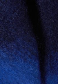 Tessuto in feltro blu navy con una superficie morbida e texture. Presenta diverse tonalità di blu e sottili motivi di fibra intrecciati.