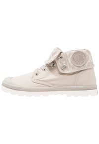 Stivaletti in canvas beige chiaro con punta in gomma e suola testurizzata. Presentano una patta e un logo impresso sul lato.