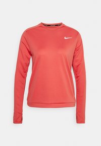 Korallin värinen pitkähihainen urheilupaita pyöreällä kaula-aukolla, hihoissa peukalonreiät ja valkoinen Nike-swoosh-logo rinnassa.