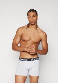 Graue Boxershorts mit einem schwarzen elastischen Bund und weißem Text. Die Shorts haben einen figurschmeichelnden Schnitt und bestehen aus einem weichen Baumwollgemisch.