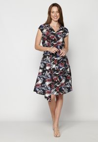 Rochie cămașă florală cu un fundal întunecat și modele roșii, albe și albastre. Mânecile scurte, închidere cu nasturi pe față și curea legată în talie.