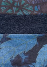 Échantillons de textiles dans des nuances de bleu et de gris foncé. Les motifs incluent des dessins abstraits de feuilles, des tissages texturés et des finitions lisses.