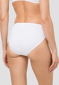 Weiße Baumwollslips mit nahtlosem Design, weichem Stoff und zarten, gewellten Rändern für Komfort und Passform.