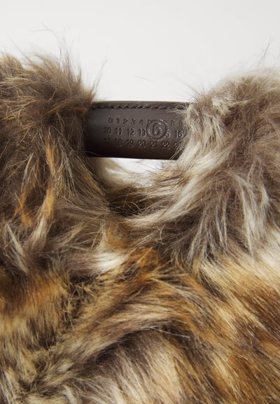 Mākslīgā īsā kažokādas apkakle brūnu un krēmkrāsas toņos, ar mīkstu tekstūru un ādas birku ar ciparu detaļām.