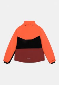 Veste colorée avec des sections orange, noir et bordeaux, dotée d'un col montant, de poignets élastiques et d'un logo en bas.