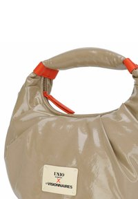 Sac à main beige brillant de forme arrondie, doté d'une poignée supérieure avec un accent orange. Comprend une fermeture éclair et une étiquette de marque.