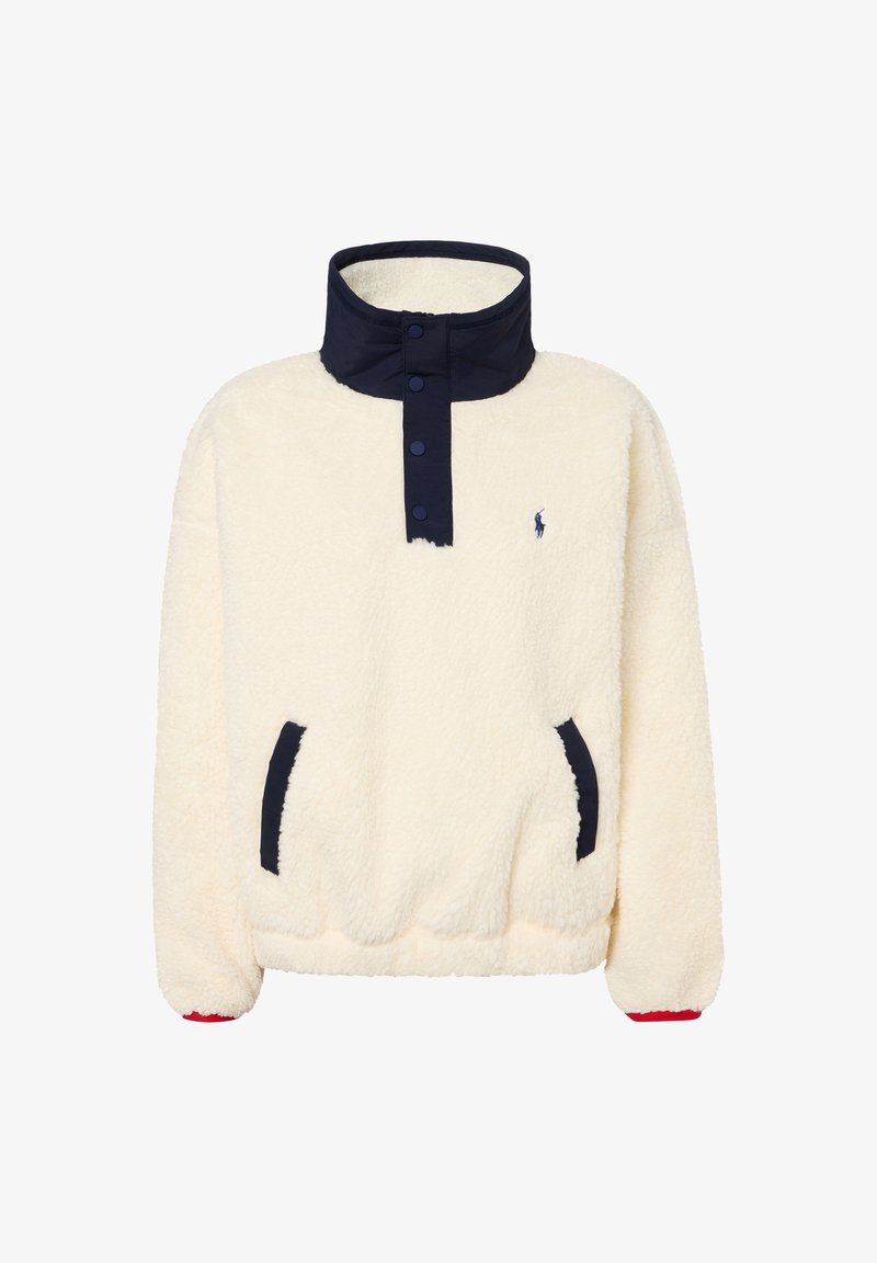 Cream-colored sherpa fleece pullover with navy snap button placket and pocket trims, high collar, and small embroidered logo on the chest.