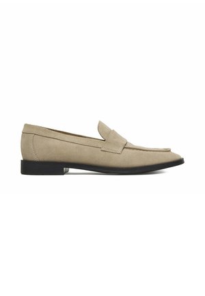 Mocassino in suede beige con suola piatta nera, punta arrotondata e classico dettaglio a fascia per inserire la moneta, mostrato di profilo su sfondo bianco.