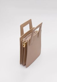 Beżowa torebka z sztucznej skóry z dwoma uchwytami na górze, złotymi elementami i zamknięciem na zamek. Gładka tekstura i minimalistyczny design.