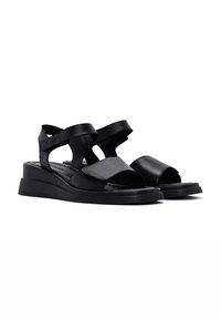 Sandali in pelle neri con design open-toe, cinturini regolabili e tacco a zeppa per un'altezza e un comfort aggiuntivi.