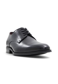 Scarpa oxford nera in pelle con punta tonda, superficie liscia e finitura satinata. Presenta sei occhielli e un tacco basso impilato.