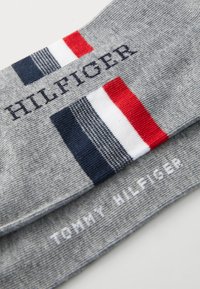 Grå mönstrade strumpor med blå, vit och röd rand. Har "HILFIGER" och "TOMMY HILFIGER" logotyper i marinblå och vit brodering.