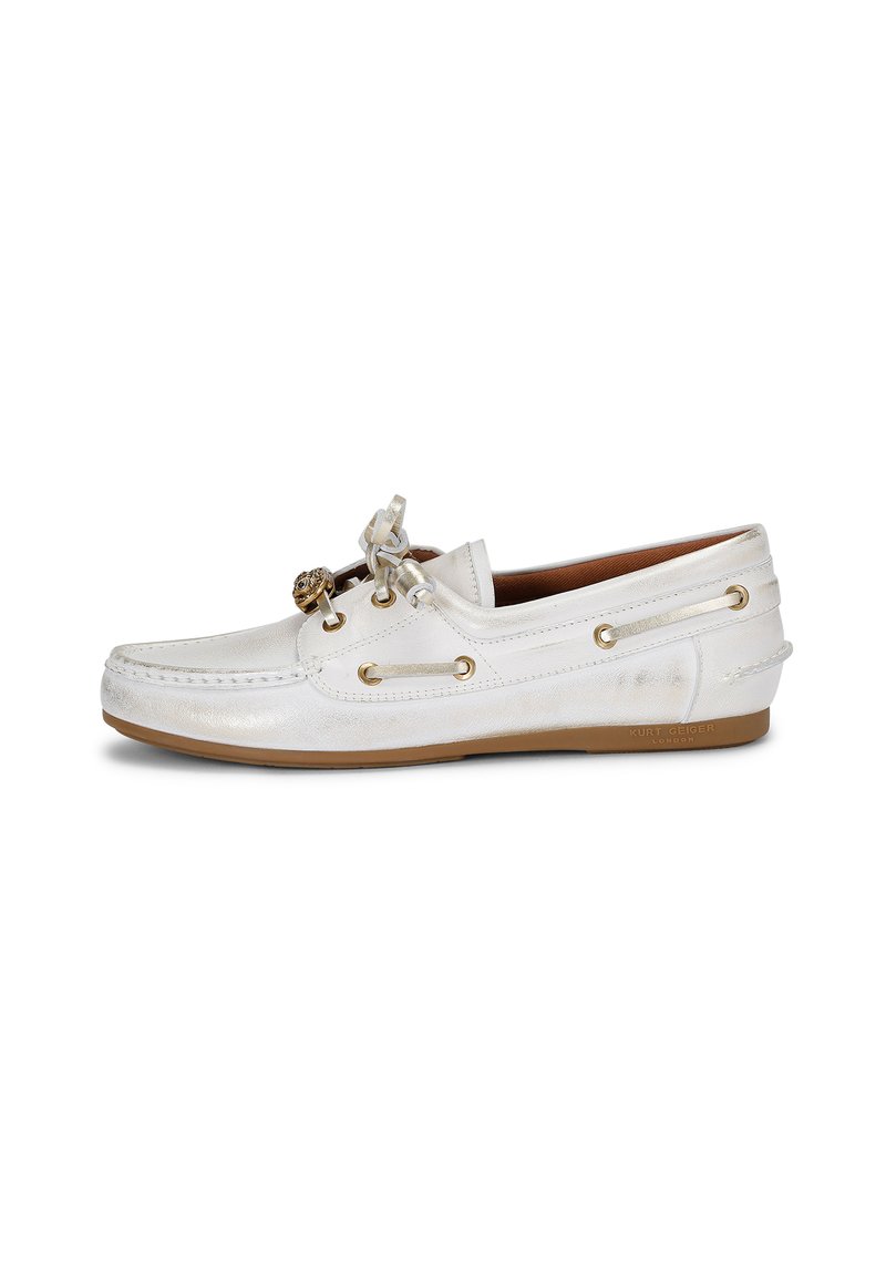 Scarpa da barca in pelle bianca con finitura testurizzata, dettagli in metallo dorato, lacci decorativi e suola in gomma. Presenta grommet laterali per un tocco di stile.