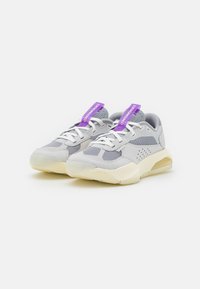 Gray sneakers featuring mesh and synthetic materials, with a textured design, padded collar, and purple tags. Cream-colored soles.