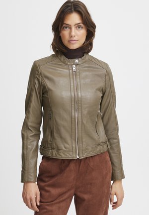 Veste en cuir vert olive au design ajusté, avec un col montant, fermeture éclair et deux poches latérales ; portée par-dessus un haut marron foncé.