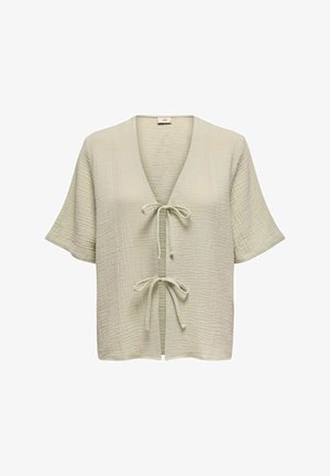 Bluză de culoare verde deschis, texturată, cu mâneci scurte, decolteu în V și închidere la fața. Prezintă un model de țesătură crăpată pe toată suprafața.