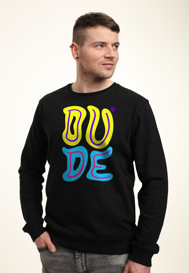 Sudadera negra con un gráfico de texto colorido "DUDE" en amarillo, azul y púrpura. Tejido suave con cuello redondo y puños de canalé.