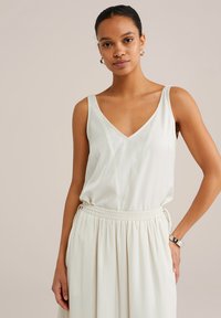 Rochie fără mâneci de culoare crem deschis, cu decolteu în V, talie elastică gathered și material fluid. Textură netedă și design minimalist.