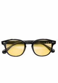 Occhiali da sole in plastica nera dal design retro, con lenti gialle e una montatura acuta e angolare. Nessun marchio visibile sulla parte frontale.