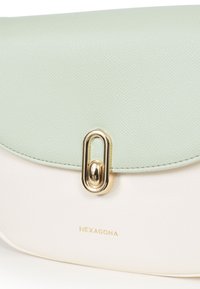 Borsa a tracolla verde chiaro e crema realizzata in ecopelle testurizzata, con una chiusura in metallo dorato e il nome del marchio "HEXAGONA" in rilievo.