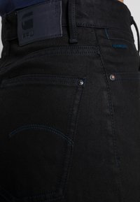 Černé džíny z denimu s modrým prošíváním, s kontrastním designem zadní kapsy a koženou nášivkou G-Star RAW na pásku.