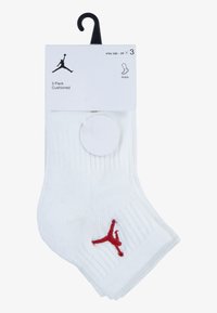 Calcetines blancos hasta el tobillo en un paquete de 3, con textura acanalada y un logo rojo de Jordan. Con acolchado para mayor comodidad, y una etiqueta colgante para exhibición.