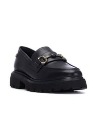 Mocasines de cuero negro cuentan con una suela gruesa y texturizada, costuras prominentes y un acento de hardware dorado en la parte frontal.