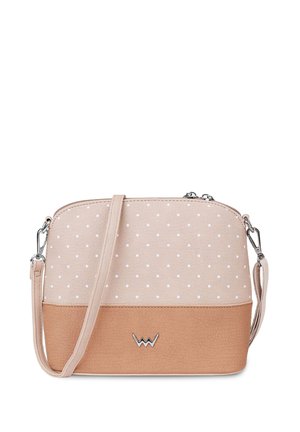 Crossbody bag in light pink and tan artificial leather, featuring white polka dots, rounded shape, silver hardware, and embossed logo detail.