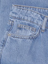 Jeans de mezclilla azul claro con un bolsillo frontal que presenta costuras naranjas en contraste y un remache de metal, mostrando una textura suave.