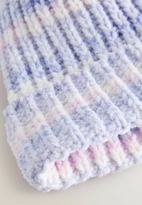 Strikket hue i lyse lilla med pastelfarver i pink og blå. Har ribbet mønster og blødt, fuzzy garn.