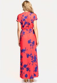 Maxi-Kleid aus korallenfarbenem Stoff mit floralem Muster in marineblau. Kurze Ärmel, elastischer Bund und glatte Textur. Einfaches Design.