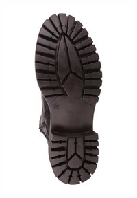 Suela de bota de goma negra con patrones de banda de rodadura profunda, con ranuras angulares y una superficie plana, marcada con la talla 36.