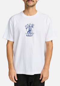 White cotton t-shirt featuring blue graphic print with a skull design and text. Short sleeves, crew neck, relaxed fit.