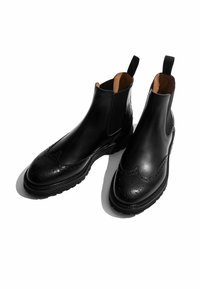 Botas Chelsea de cuero negro con un acabado suave, detalles de brogue en la punta, paneles laterales elásticos y una suela de goma duradera.