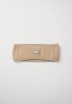 Beige fleece headband with a rectangular "RAINS" label centered on a plain white background.