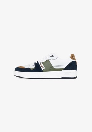 Sneakers featuring a white leather upper with navy and olive suede accents. Round toe, flat laces, with a brown tab on the heel. White sole.