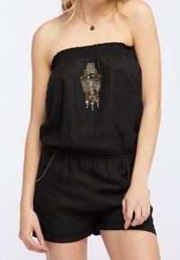 Mono negro sin tirantes con un escote elástico, decorado con un adorno central de cuentas y pantalones cortos sueltos y cortos.