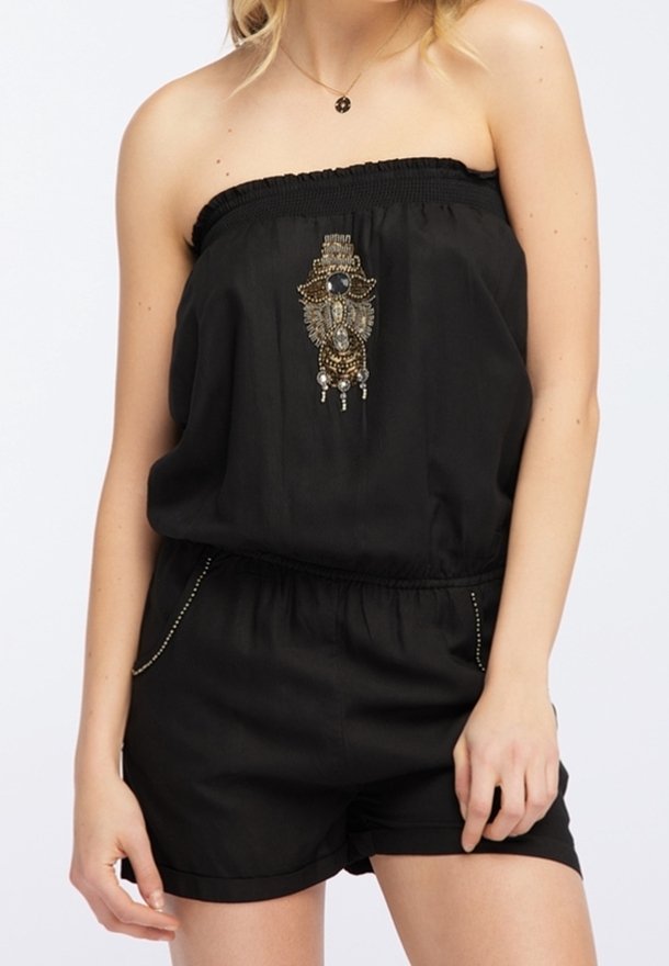 Mono negro sin tirantes con un escote elástico, decorado con un adorno central de cuentas y pantalones cortos sueltos y cortos.