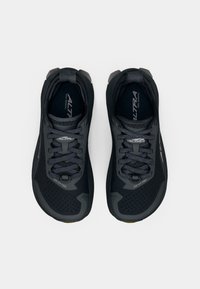 Sapatos de trail running pretos com um upper de malha respirável, detalhes texturizados, atacadores pretos e uma sola em borracha. Sem logótipos proeminentes visíveis.