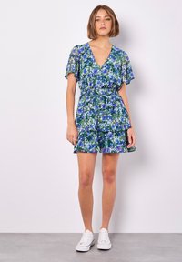 Blumenkleid mit kurzen, flatternden Ärmeln, V-Ausschnitt und elastischem Taillenbund. Merkmale ein geschichtetes Rockteil mit blauen und grünen Veilchen auf dunklem Hintergrund.