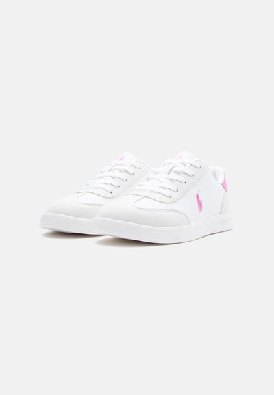 Λευκά sneakers χαμηλού ύψους με ροζ λογότυπο και λεπτομέρεια στη φτέρνα, κορδόνια και καουτσούκ σόλες σε απλό λευκό φόντο.