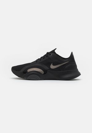 Black Nike running shoe with lace-up design, gray swoosh logo, textured sole, and curved cushioning detail on the side.