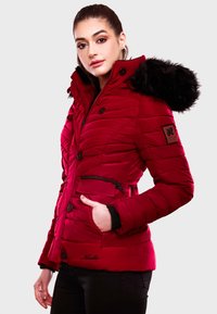 Red padded jacket with a fur-lined hood, button closures, front zip pocket, shoulder patch, and ribbed cuffs. Features a smooth texture.