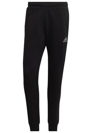 Sorte joggingbukser lavet af blødt stof med elastisk linning, indsnævrede ben og subtile sømdetaljer. Har et præget logo på siden.