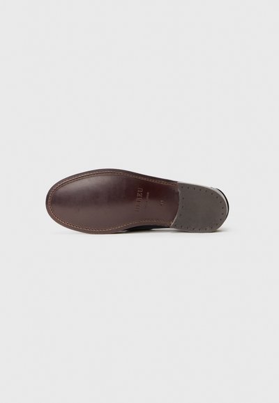 Suela de zapato de cuero marrón con un acento de ante gris, forma redondeada, textura suave y costura en contraste. Presenta un estampado del logo y perforaciones.