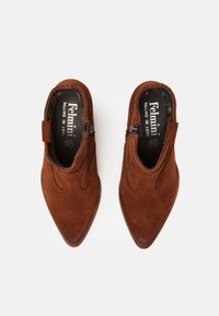 Zapatos de ante marrón tipo slip-on con puntera puntiaguda, que cuentan con costuras decorativas y una cremallera lateral. Forrados con una tela de patrón multicolor.