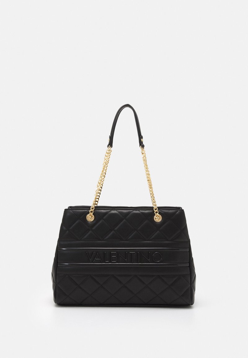 Black quilted handbag with a smooth texture, gold chain shoulder straps, and a prominent embossed logo on the front.