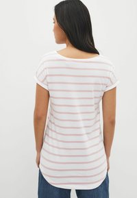 T-shirt léger blanc avec des rayures roses, doté d'un large col et de manches retournées, conçu avec un ourlet courbé légèrement plus long.